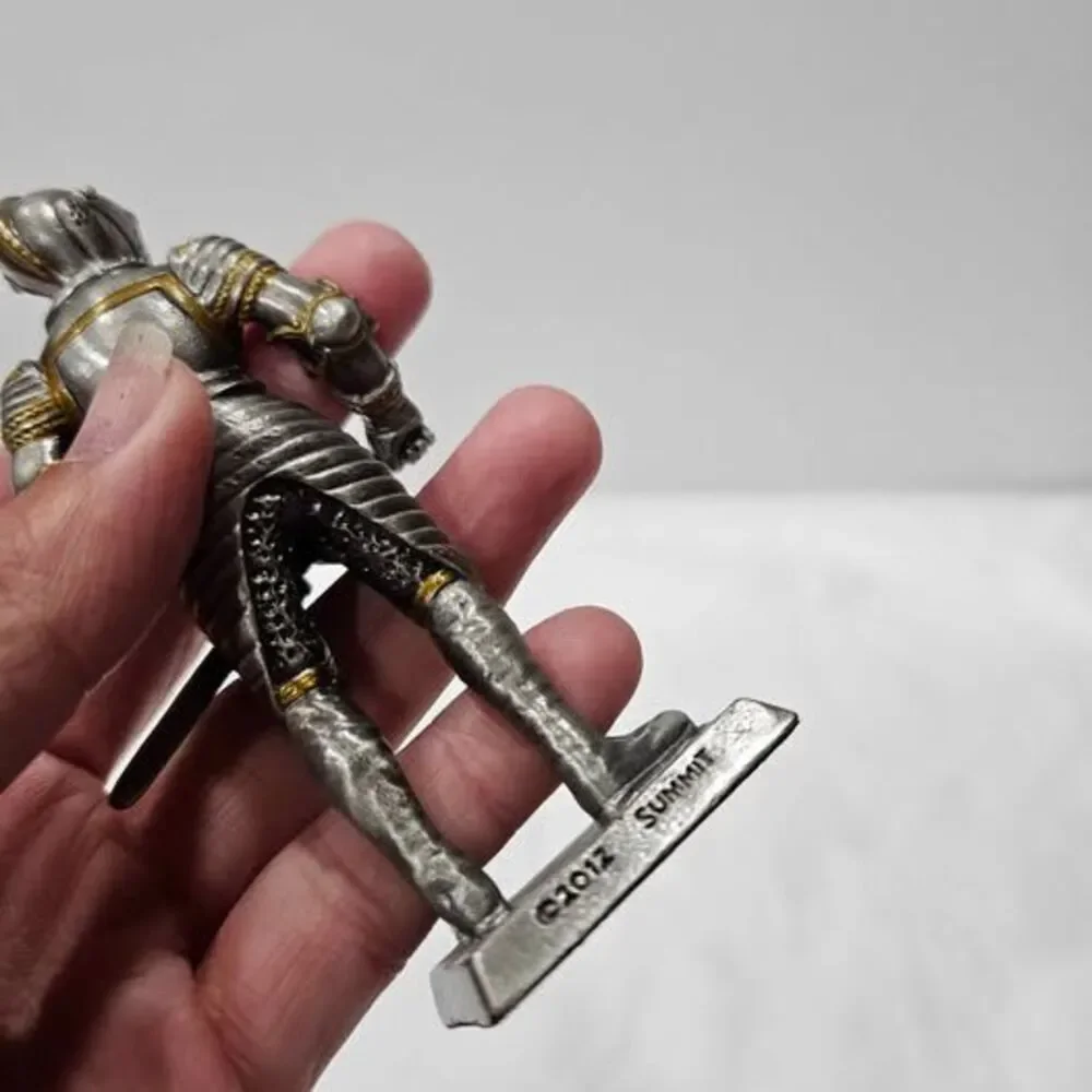 Small metal knight figurine with armor and sword